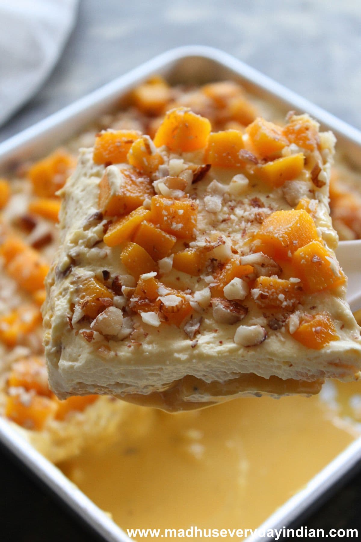 a slice of mango tres leches cake scooped out 