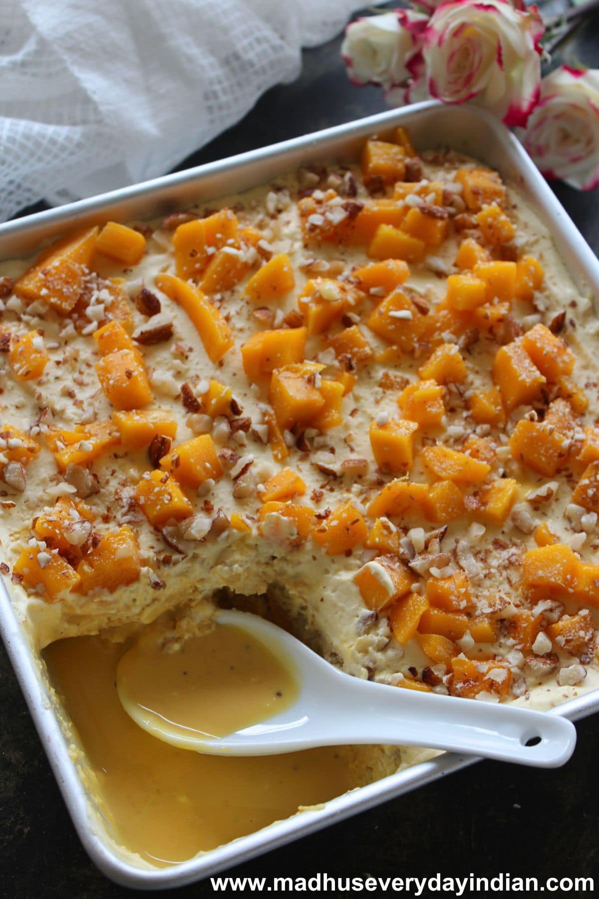 mango tres leches cake served in a tray with a spoon